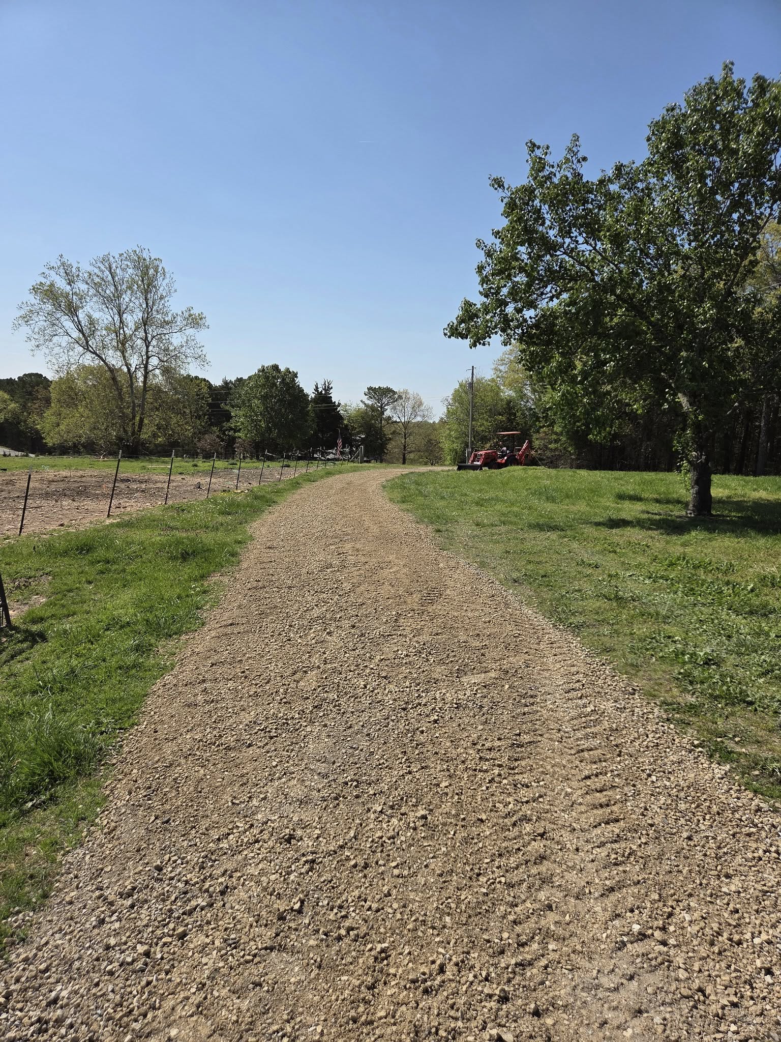 a driveway to a home in a wooded area